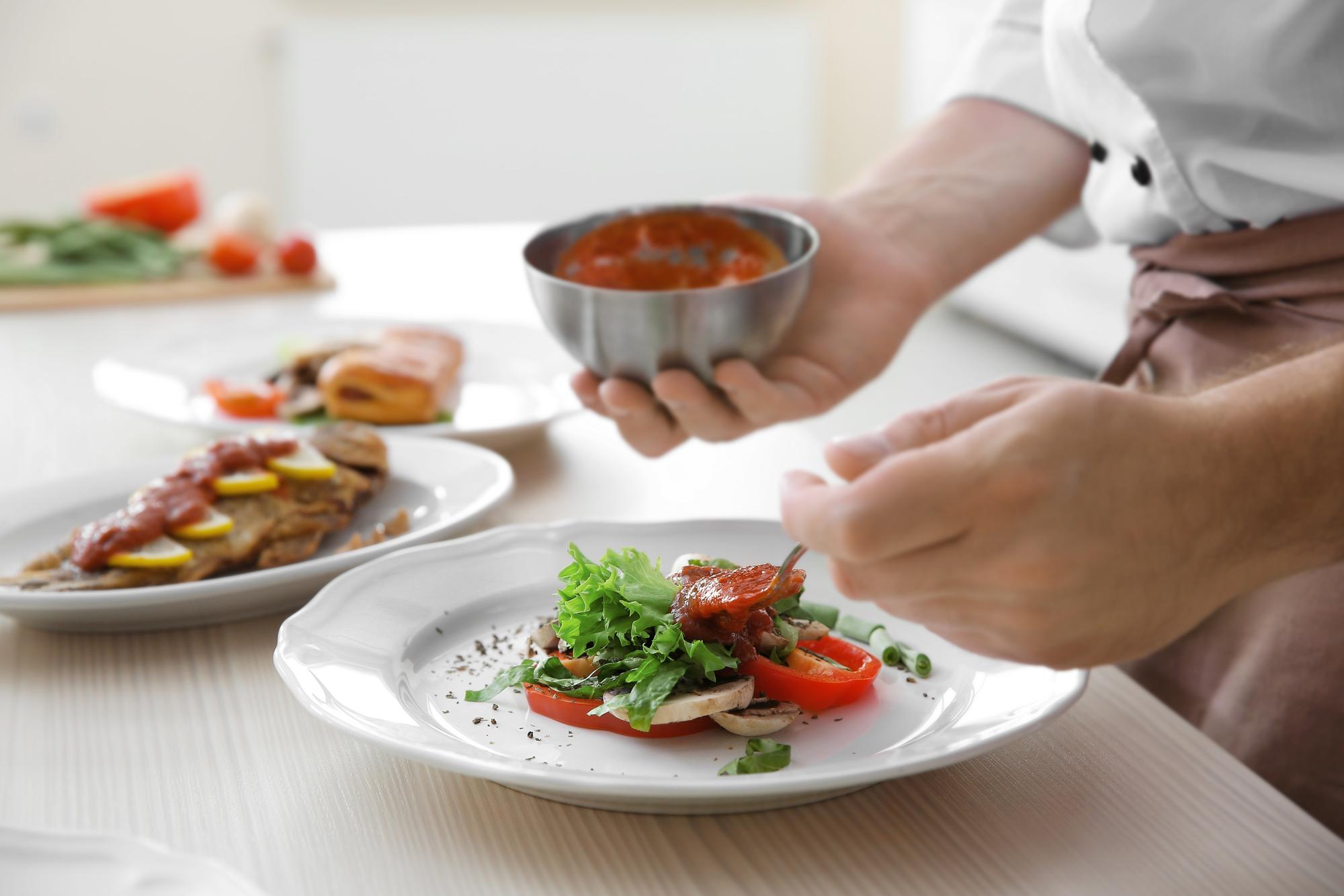 Chef preparing plated dish in warm kitchen